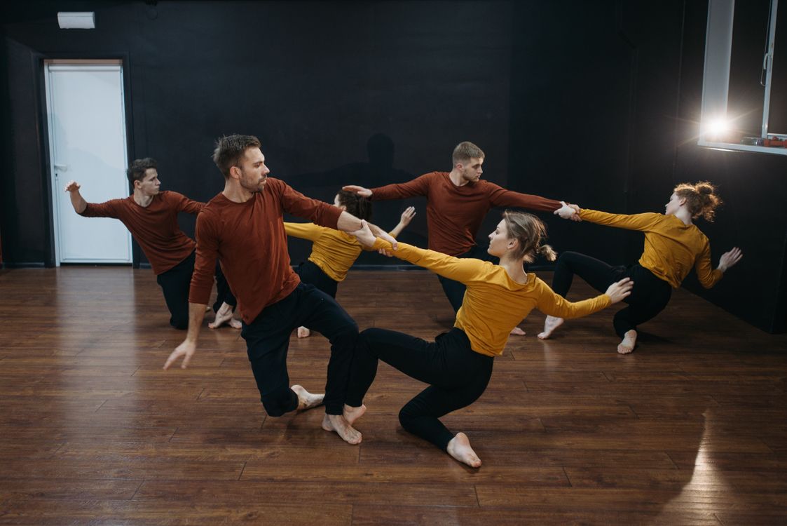 Dancers working through a contemporary sequence together in a rehearsal studio